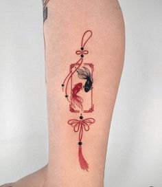 a woman's leg with a red and black tattoo design on the lower leg