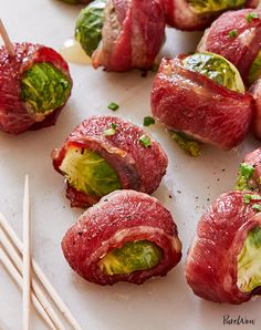 several pieces of meat and vegetables on a plate with chopsticks next to them