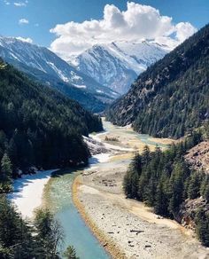 a river flowing through a valley surrounded by mountains