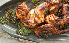 grilled chicken and broccoli on a serving platter with utensils