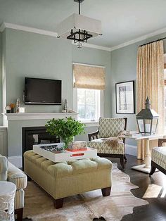 a living room filled with furniture and a flat screen tv mounted on the wall above a fireplace