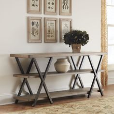 a wooden table sitting next to a wall with pictures on it