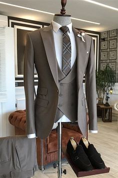 a suit and tie sitting on top of a mannequin's dummy in a living room