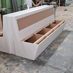 a large white bed frame with drawers in it