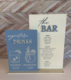 a blue and white greeting card next to a drink menu