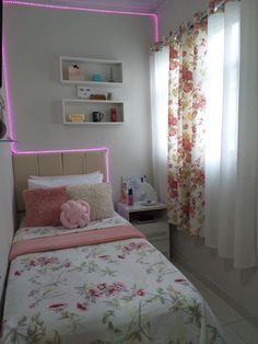 a bedroom with pink lights and floral bedding on the walls, along with curtains