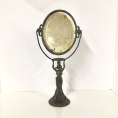 an antique looking mirror on a white surface