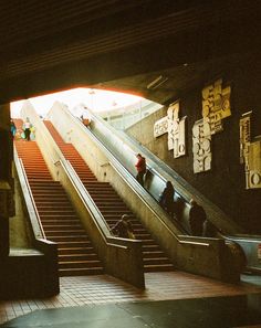 an escalator with people riding down it