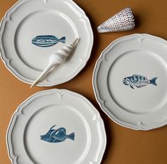 two white plates with blue fish on them