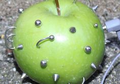 an apple with spikes on it is laying on the ground next to a charger