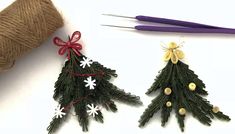 two christmas trees made out of twine and yarn next to a spool of thread