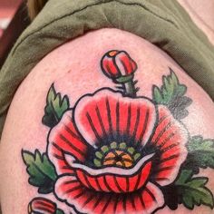 a close up of a tattoo on the back of a person's thigh with flowers and leaves