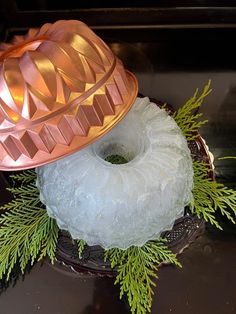 a cake with frosting and pine branches on it sitting on top of a plate