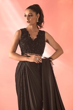 Black satin pre-draped buckle saree with placement tonal embellishments and feather detailing. Paired with a padded blouse with crystal, floral embellishments. - Aza Fashions Sleeveless Formal Pre-draped Saree, Elegant Sleeveless Georgette Pre-draped Saree, Sleeveless Party Wear Blouse For Evening, Elegant Sleeveless Pre-draped Saree For Festive Occasions, Sleeveless Evening Blouse For Party Wear, Elegant Sleeveless Pre-draped Saree For Formal, Elegant Sleeveless Pre-draped Formal Saree, Festive Elegant Sleeveless Pre-draped Saree, Elegant Sleeveless Formal Blouse