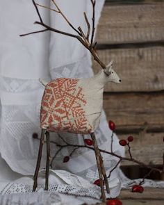 a stuffed animal sitting on top of a wooden chair next to some branches and berries