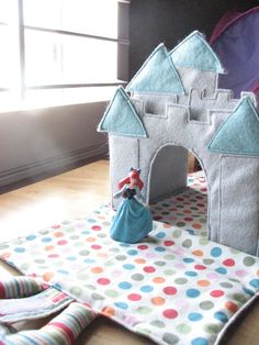 a castle made out of felt sitting on top of a table next to a window