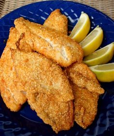 fried fish with lemon wedges on a blue plate