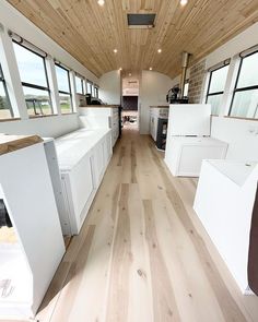 the interior of an rv with wood floors and white appliances in it's storage area