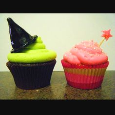 two cupcakes with green and pink frosting on them, one has a witches hat