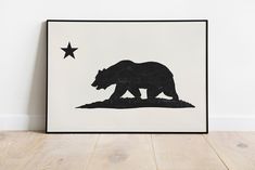 a black and white bear silhouette on a white background with a star in the corner