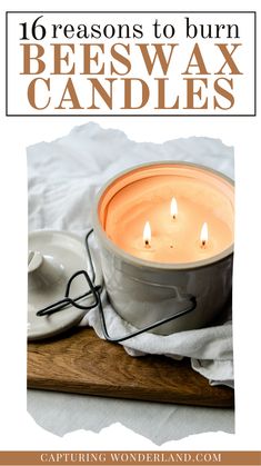 a white candle sitting on top of a wooden table next to a bowl and plate