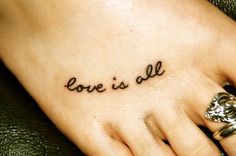 a woman's foot with the word love is all written on her left side