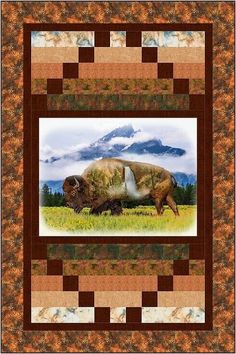 an image of a bison grazing in the grass with mountains in the backgroound