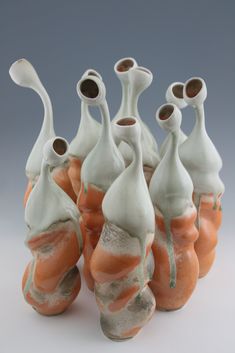 seven vases with different shapes and sizes on them, all in orange and white