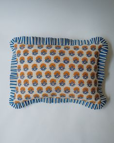 an orange and blue decorative pillow on a white background