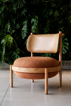 a chair sitting on top of a tiled floor next to a green plant covered wall