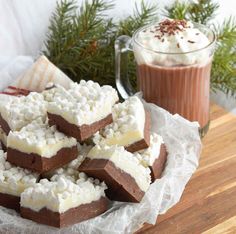 chocolate and marshmallows are stacked on top of each other in front of a cup of hot cocoa