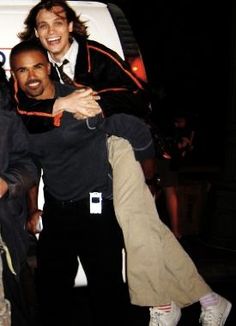 three men are posing in front of a van with their arms around each other and smiling