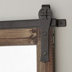 an old door handle is attached to the side of a wooden frame with a mirror behind it