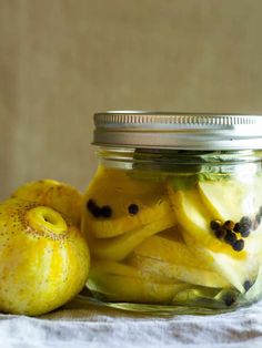 a glass jar filled with sliced fruit on top of a table