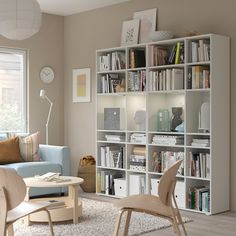 a living room filled with lots of furniture and bookshelves next to a window