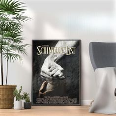 a poster on the wall next to a chair and potted plant