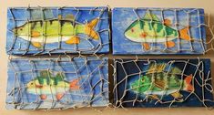 four tiles with fish painted on them