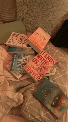 a pile of books sitting on top of a bed