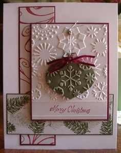 a handmade christmas ornament hanging from a string on a card with snowflakes