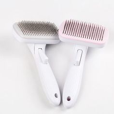 two hairbrushes sitting next to each other on a white surface with one brush in the foreground