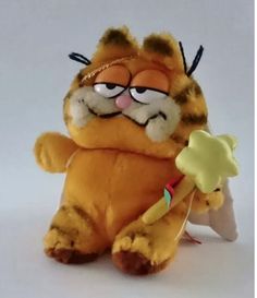 a stuffed animal holding a toothbrush in it's mouth and wearing glasses, sitting on a white surface