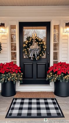 two christmas wreaths on the front door of a house with poinsettias