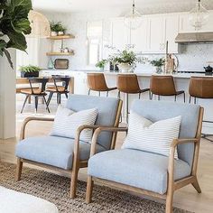 a living room filled with furniture next to a kitchen and dining room table covered in plants