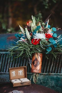 a bouquet of flowers in a vase next to an old truck