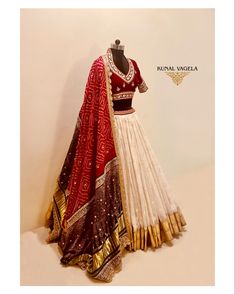 a woman's red and white lehenga with gold details on the skirt