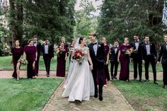 a bride and groom walking down a path with their bridal party in the background