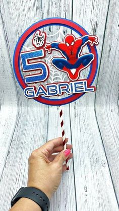 a hand holding a candy cane in front of a sign that reads 5 gabril