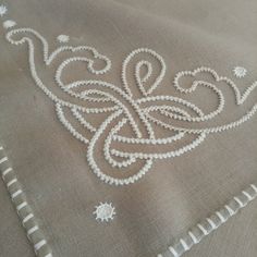 an embroidered design is on the side of a piece of cloth with white stitching