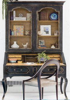 an old desk with a chair and bookshelf in front of it on top of a blue rug