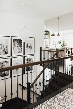 a staircase with pictures on the wall above it and an area rug underneath that is also in front of the stairs